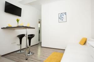 a white room with a bar and two stools at Apartment Antonio in Vir