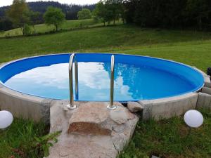 Una gran piscina azul con dos postes de metal. en Haus Erlenmoos, en St. Georgen im Schwarzwald