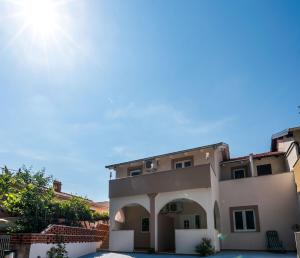 a large white house with an archway in front of it at Apartment Antonio in Vir
