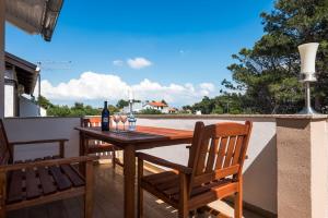 a wooden table with two chairs and a bottle of wine at Apartment Antonio in Vir