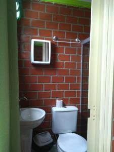 a bathroom with a toilet and a brick wall at Pousada Monte Serrat in Bonito +52 photos
