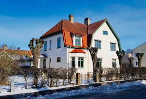 a large white house with an orange roof at Villamilsten B&B in Lidköping