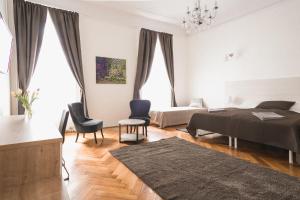 ブダペストにあるOzone Private Roomsのベッドルーム(ベッド1台、ソファ、椅子付)