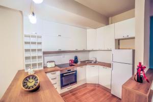 a kitchen with white cabinets and a wooden floor at Apartment Dudanovski in Ohrid