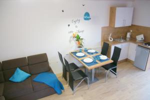サルビノボにあるKoral Apartmentyのテーブル、椅子、ソファが備わるキッチン