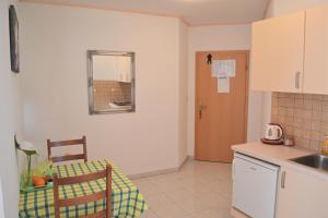a kitchen with a sink and a table and a chair at Apartments Dragun in Podstrana