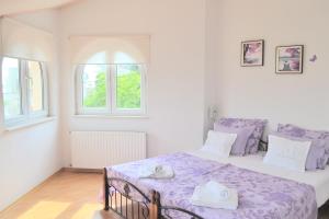 a bedroom with a bed with a purple blanket at Apartments Dragun in Podstrana