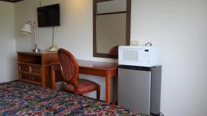 a hotel room with a desk and a bed and a mirror at Stay Inn in Port Clinton