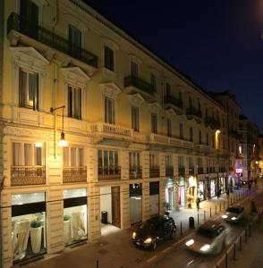 a building with cars parked on a street at night at CHC Hotel Torino Castello in Turin