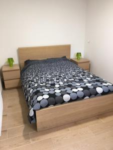 1 dormitorio con 1 cama con edredón blanco y negro en Les Mimosas Apartments, en Villelongue-dels-Monts