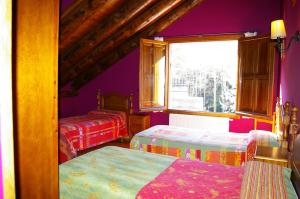 a bedroom with two beds and a window at Hosteleria Santa Cruz in Santa Cruz de la Serós