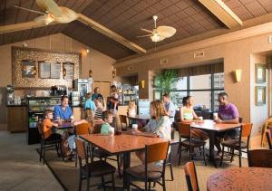 Sea Crest Oceanfront Resort في ميرتل بيتش: مجموعة من الناس يجلسون على الطاولات في المطعم