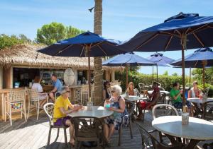 a group of people sitting at tables with umbrellas at Sea Crest Oceanfront Resort in Myrtle Beach
