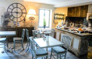 a dining room with a table and a large clock at Le Petit Chateau in Châteauneuf-de-Gadagne