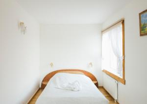 ein Schlafzimmer mit einem Bett und einem Fenster in der Unterkunft Jurodis in Jurbarkas + 3 Fotos