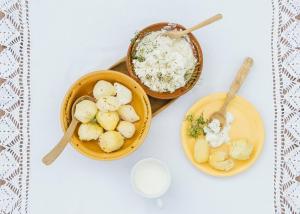 Ein Tisch mit Schüsseln mit Essen und einer Schüssel Milch in der Unterkunft Jurodis in Jurbarkas