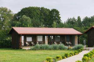 ein kleines Haus mit Stühlen in einem Hof in der Unterkunft Jurodis in Jurbarkas