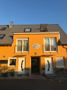 an orange building with white doors and windows at Pension LeLiLa Rust - ex Gästehaus Milella in Rust