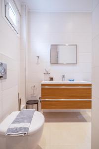 a white bathroom with a sink and a toilet at Kamis Suite in Neos Marmaras