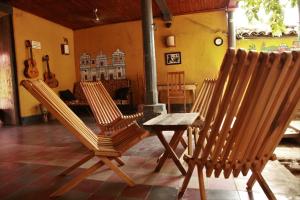 two chairs and a table in a room with a guitar at Hostal La Tortuga Booluda in León