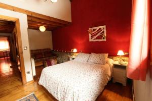 1 dormitorio con cama y pared roja en Casa Gorio, en San Mamés