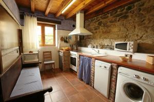 una cocina con lavadora y secadora. en Casa Gorio, en San Mamés