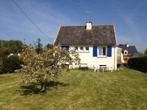 a white house with a tree in the yard at Ma maison in Créhen