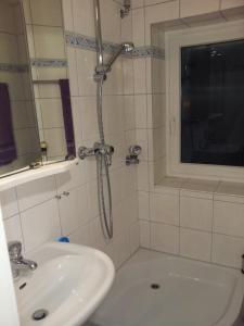 a bathroom with a shower with a sink and a sink at direktamstrand-sylt in Westerland (Sylt)