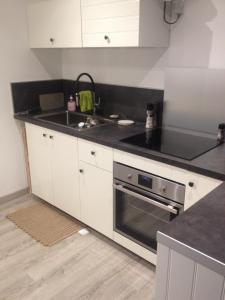 a kitchen with a sink and a stove top oven at Ma maison in Créhen