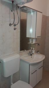 a bathroom with a toilet and a sink and a mirror at Anka's Beach in Komiža +42 photos