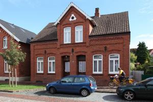 a man riding a bike in front of a brick house at Großstrasse 18 A in Leer