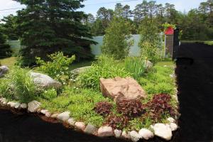 a garden with rocks and plants in a yard at Mackinac Lake Trail Motel in Mackinaw City