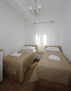 een kamer met 2 bedden en een kroonluchter bij Apartments Obitelj Vuletić in Makarska
