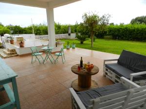 a patio with a couch and a table and chairs at I Colori degli Agrumi Holiday Home in Floridia