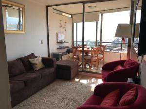 uma sala de estar com um sofá, cadeiras e uma mesa em Gran departamento con vista al mar em Concón
