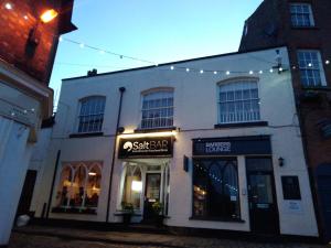 a building with a store on a street with lights at Sleep, Eat, Repeat Bed and Breakfast in Macclesfield