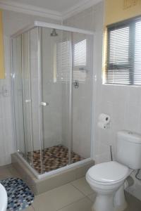 a bathroom with a shower with a toilet and a sink at Mbopha Guest House in Ulundi