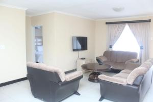 a living room with two chairs and a table at Mbopha Guest House in Ulundi