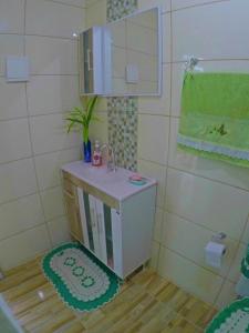 a small bathroom with a sink and a mirror at Residencial Recanto Paraíso BC - Flat in Balneário Camboriú +25 photos