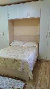 a bedroom with a bed with white cabinets at Residencial Recanto Paraíso BC - Flat in Balneário Camboriú