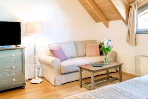 a living room with a couch and a table at BASALTINA Panzió in Balatonederics