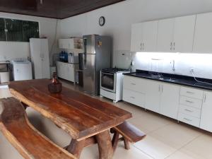 a large kitchen with a wooden table in it at Casa Aconchego Fóz in Foz do Iguaçu
