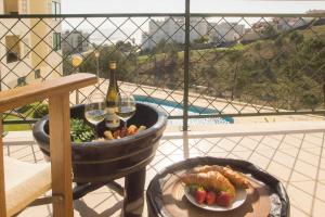 a barrel with a bottle of wine and a plate of food at Quinta das Rosas - Oceanview Apartment in Buarcos