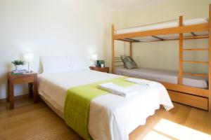 sypialnia z łóżkiem i łóżkiem piętrowym w obiekcie Quinta das Rosas - Oceanview Apartment w mieście Buarcos