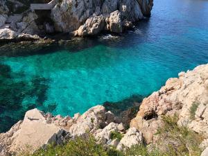 ein Wasserkörper mit Felsen und blauem Wasser in der Unterkunft Villa Franca in Santa Flavia