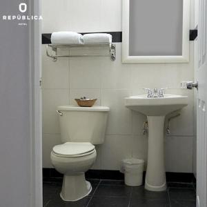 a bathroom with a toilet and a sink at Hotel República Panamá in Panama City