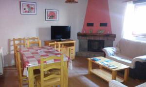 a living room with a table and a fireplace at Casa La Abuela in San Mamés