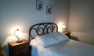 a bedroom with a bed and two night stands with lamps at Casa La Abuela in San Mamés +5 photos