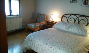 a bedroom with a bed and a chair at Casa La Abuela in San Mamés