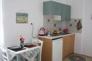 a small kitchen with a table and a table and chairs at Romantic Apartment in Adelianos Kampos